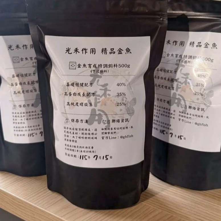 金魚育成特調飼料 500g 的包裝實拍：三包黑色夾鏈袋，正面貼著白色標籤